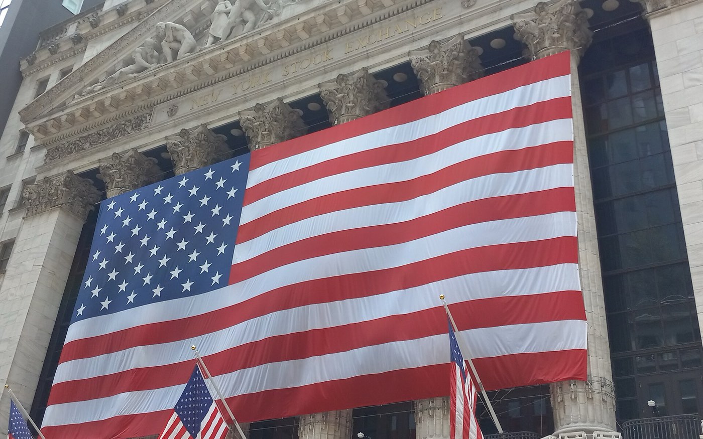 The New York Stock Exchange facade draped with a giant American flag
